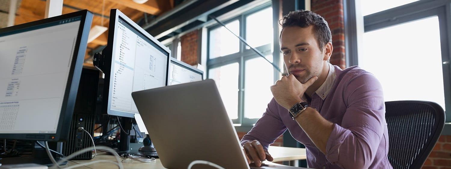 Focused business man working at laptop with SAS® Optimization software