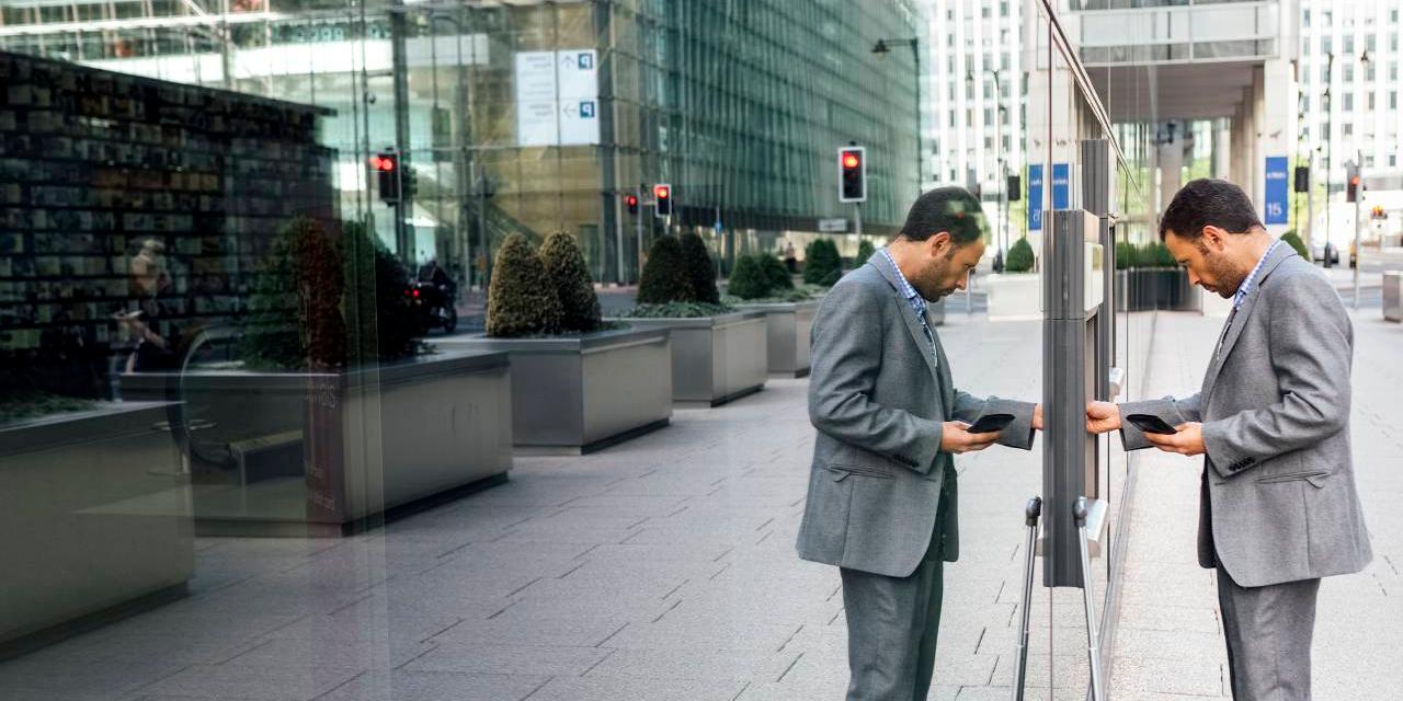 Businessman using ATM outside