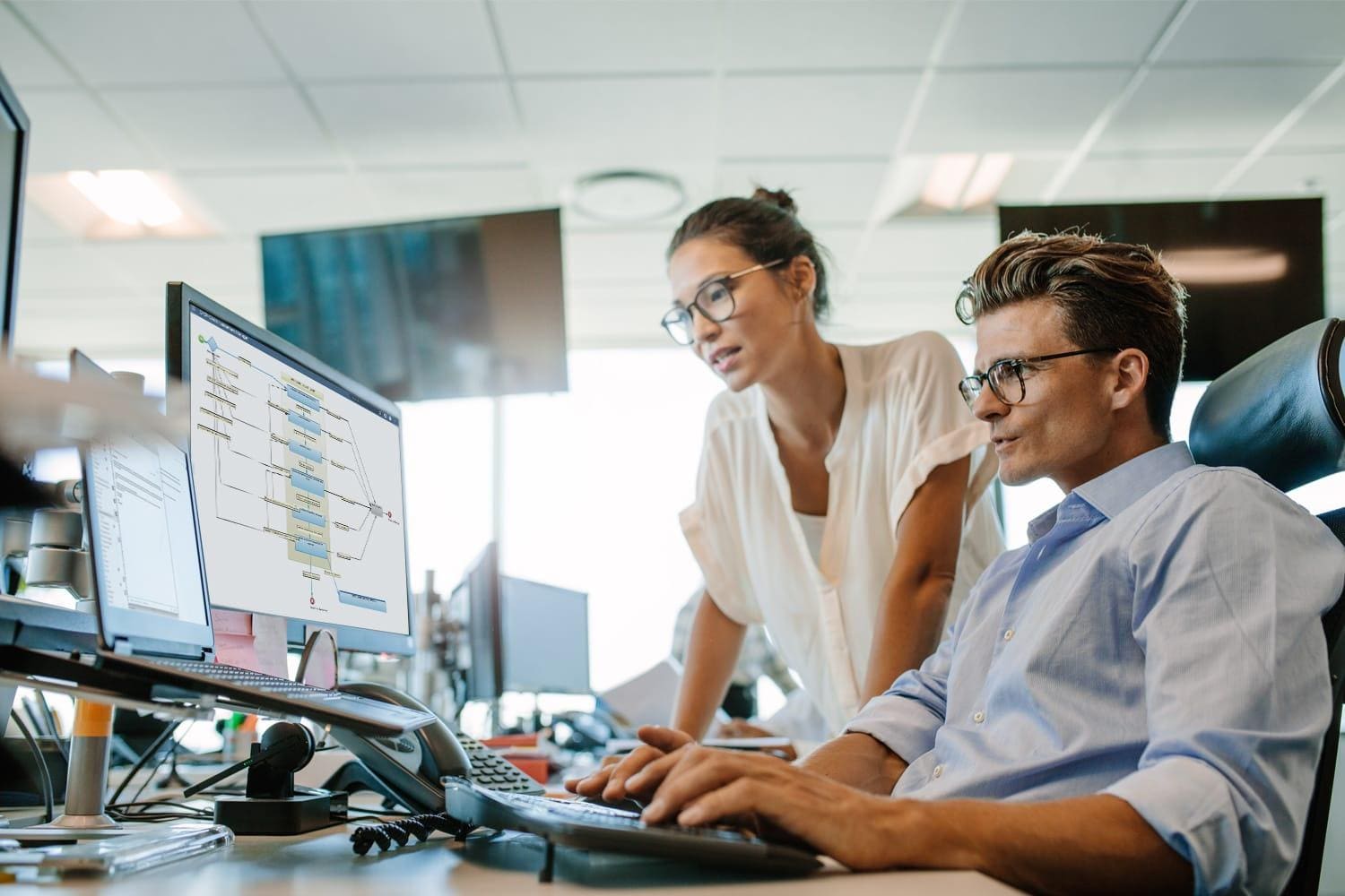 Two coworkers looking at computer