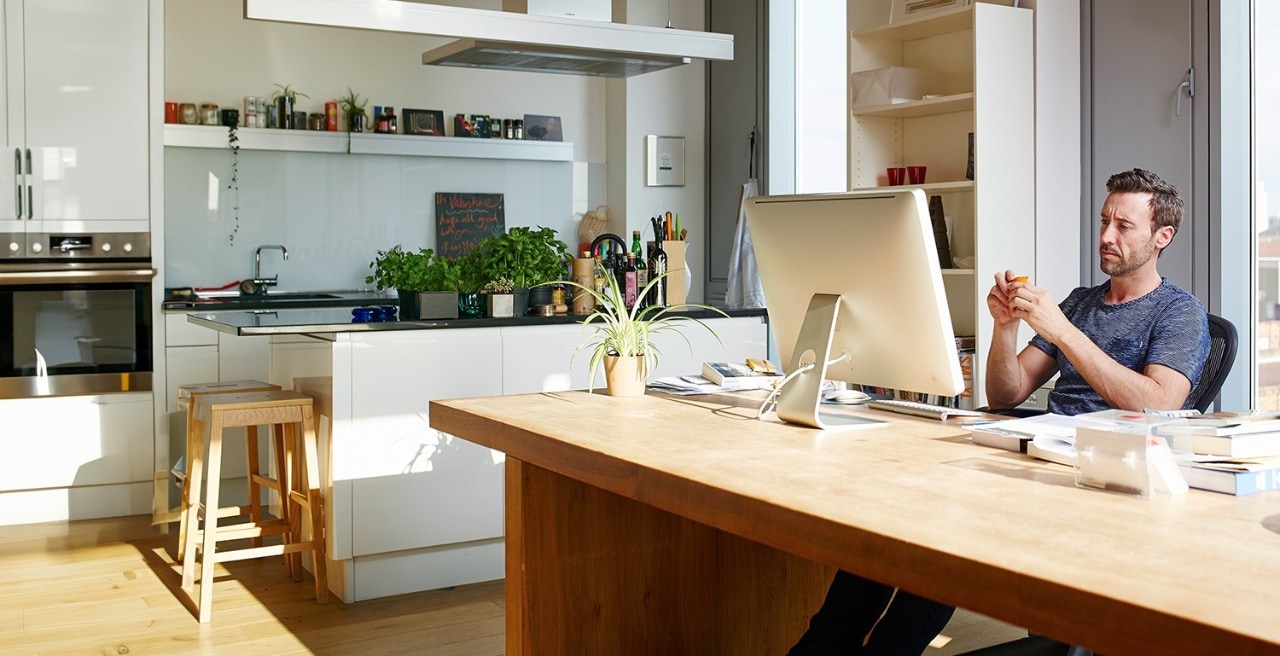 Man leaning back in desk chair looking at computer screen