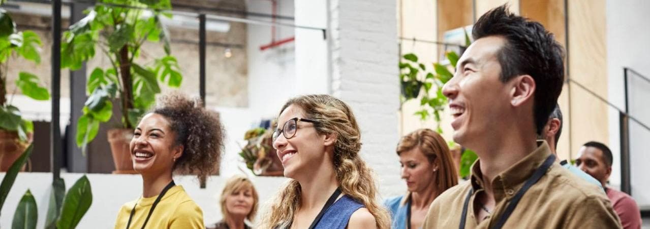 Group of young professionals in a classroom setting smiling and laughing