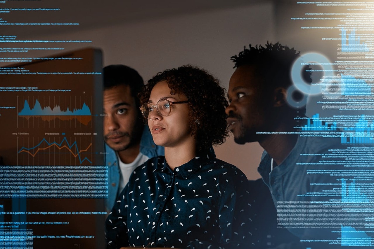 Female and male programmers working on desktop computer at night