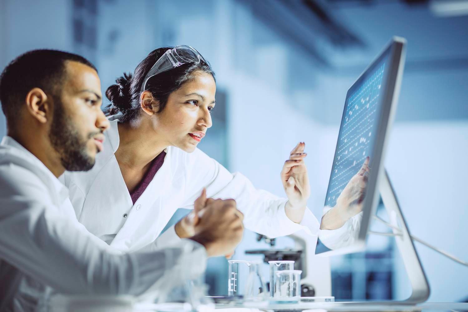 Scientists in lab reviewing monitor