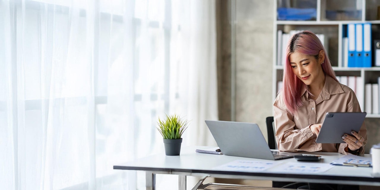 Businesswoman works on her laptop and tablet