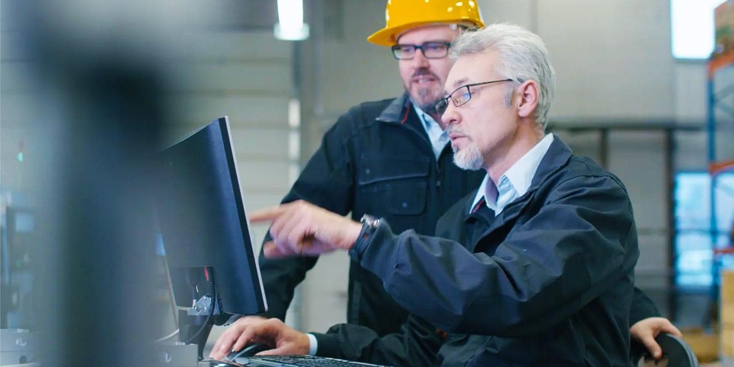 Two people monitoring operations on a tablet