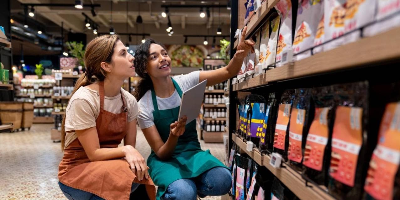 Two women working in grocery store with tablet