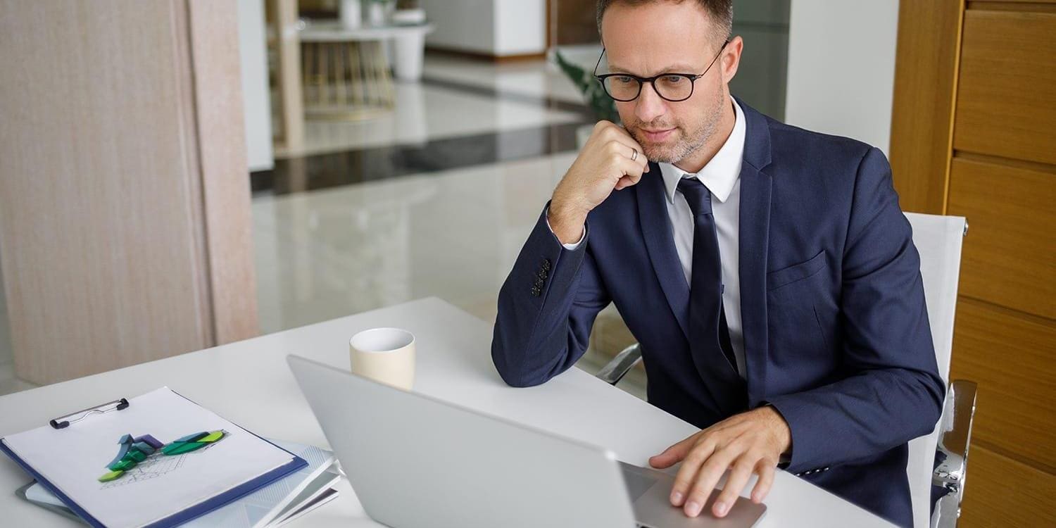 Entrepreneur looking at laptop and thinking