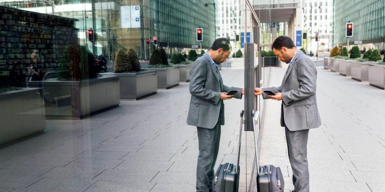 Businessman using ATM outside