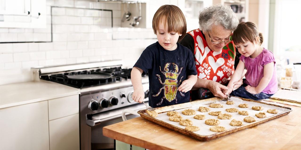 Grandmother and young grandchildren baking cookies