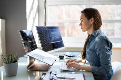 Woman programmer working on two computers