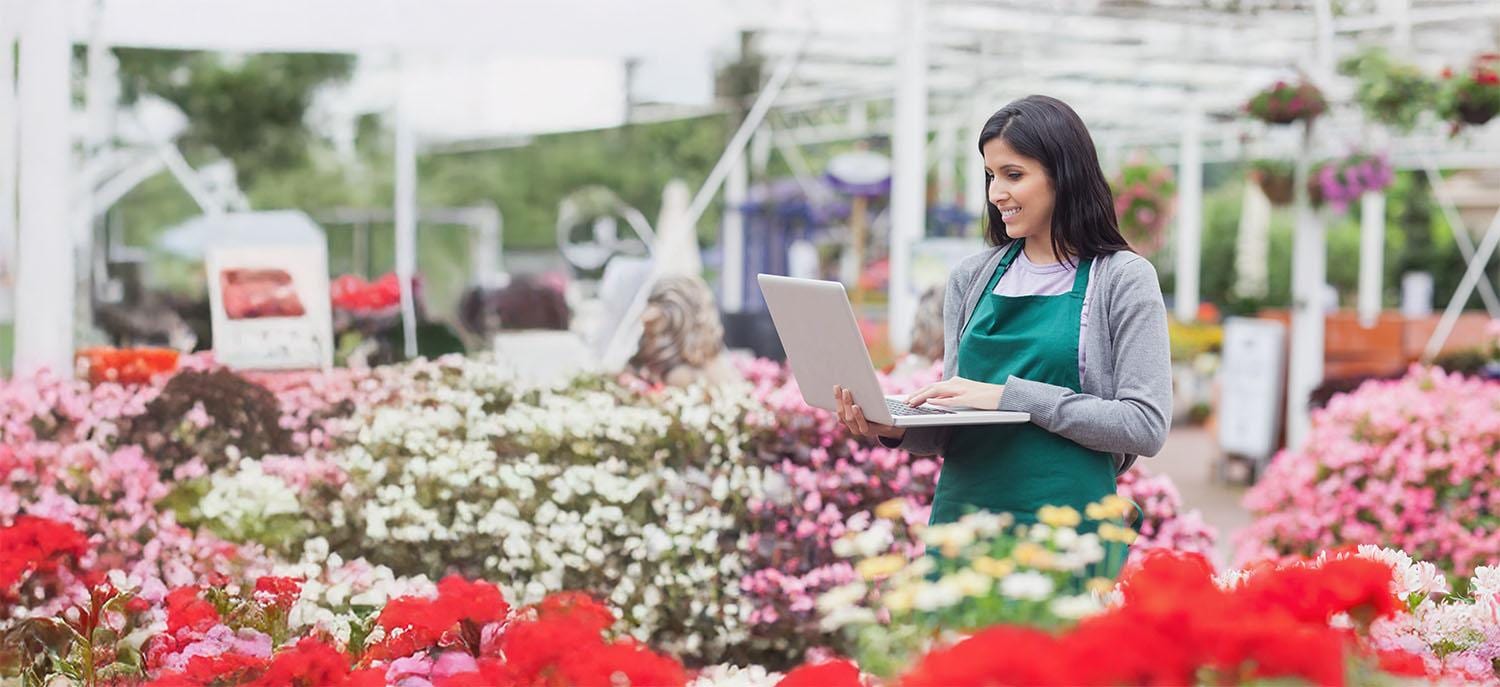 Woman with laptop in garden center