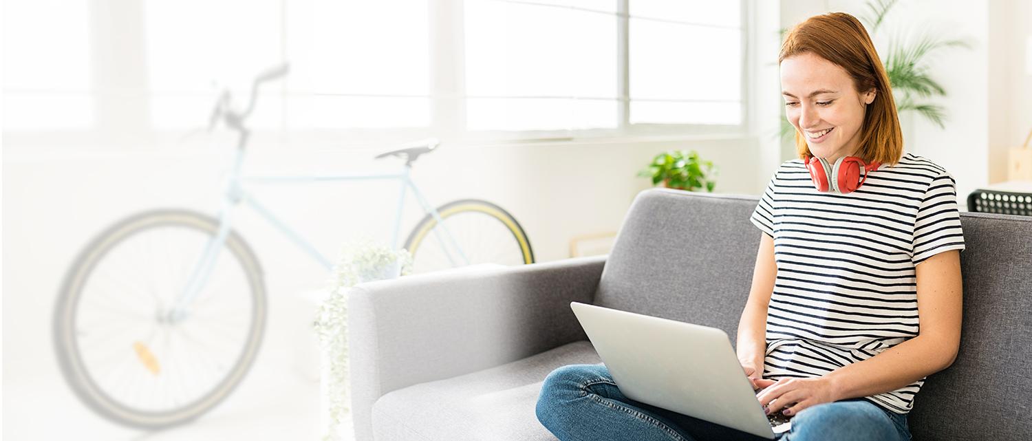 Student with headphones on couch with laptop