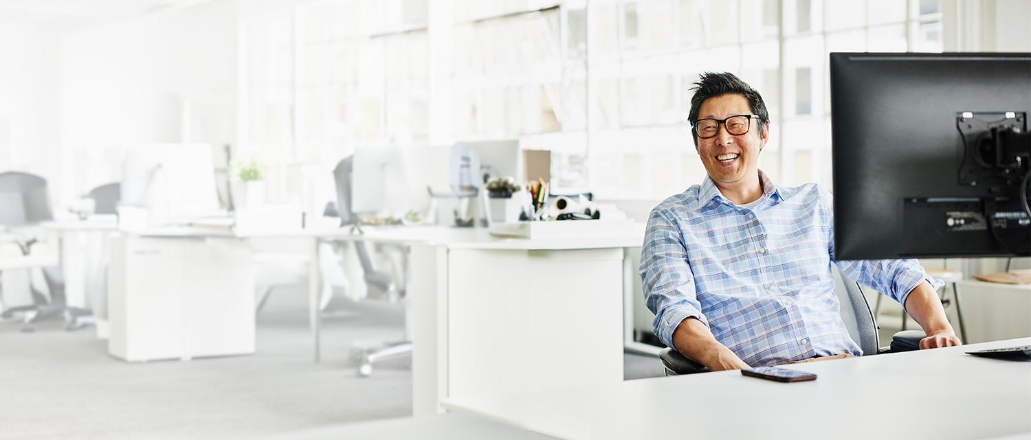 Business man smiling at his desk in office