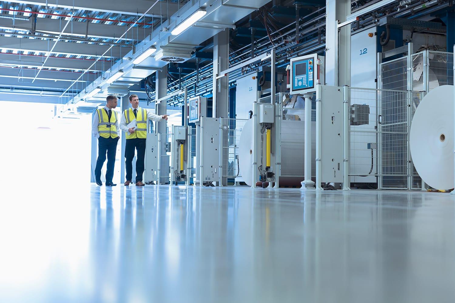 Two coworkers walking through manufacturing facility