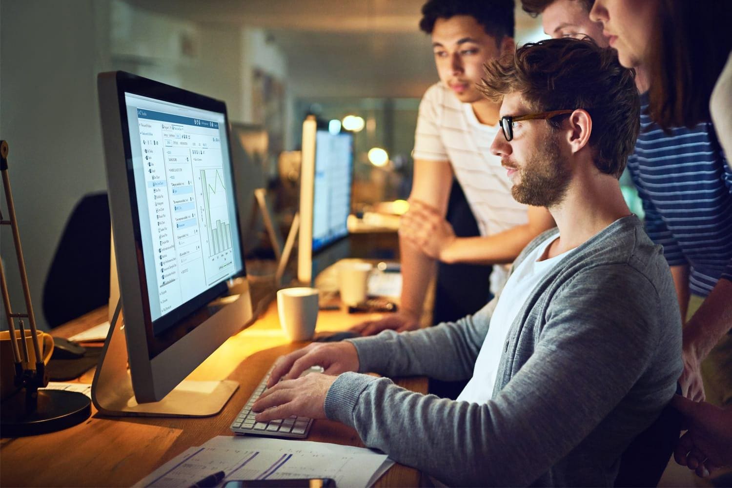 Group of young-data-scientists-around-desktop-computer