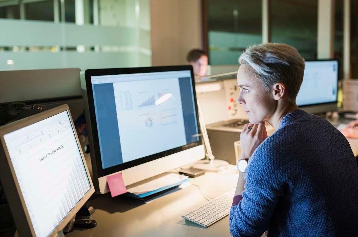 Woman working on a computer in an office at night