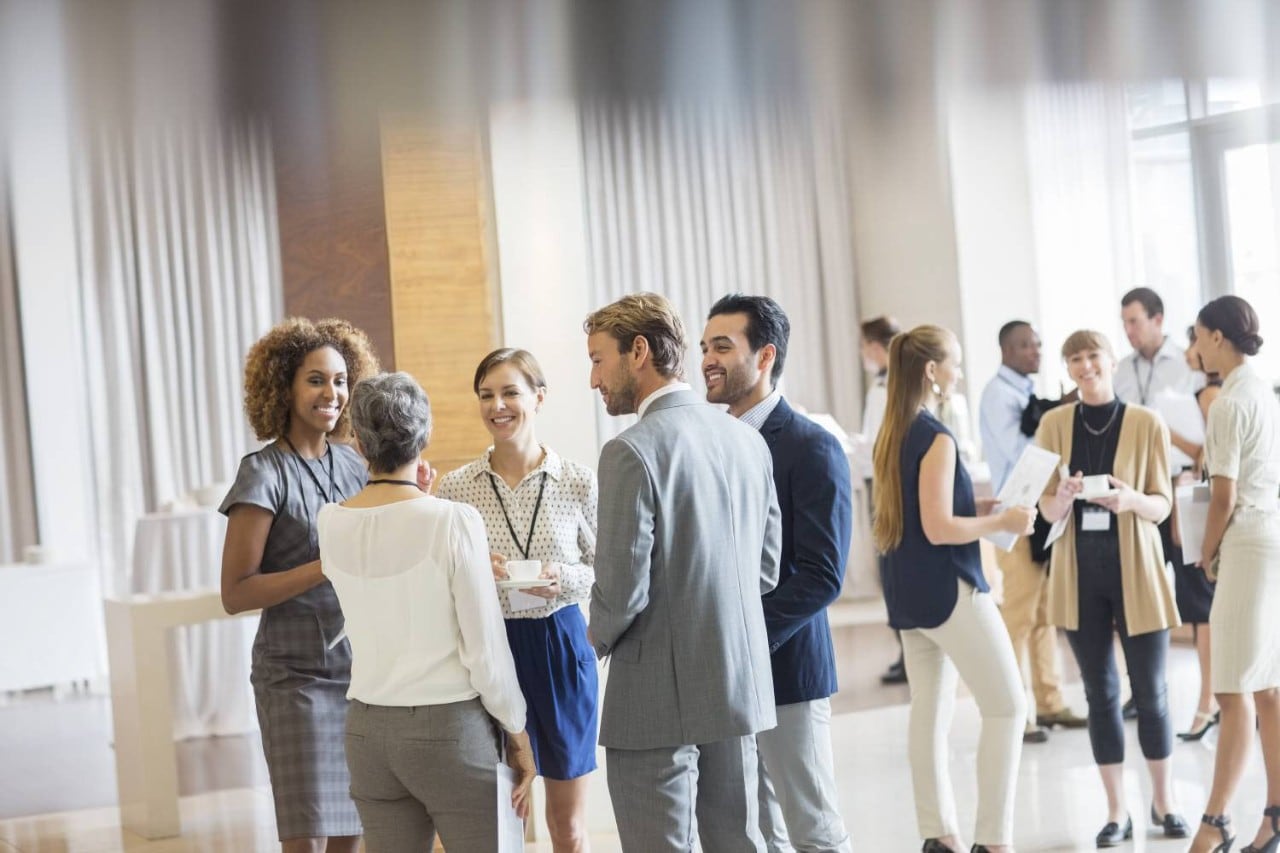 Group of business people standing in hall, smiling and talking