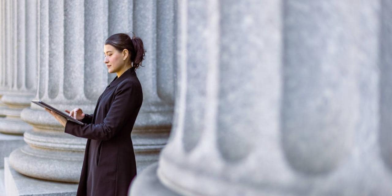 Female lawyer using tablet in front of court house