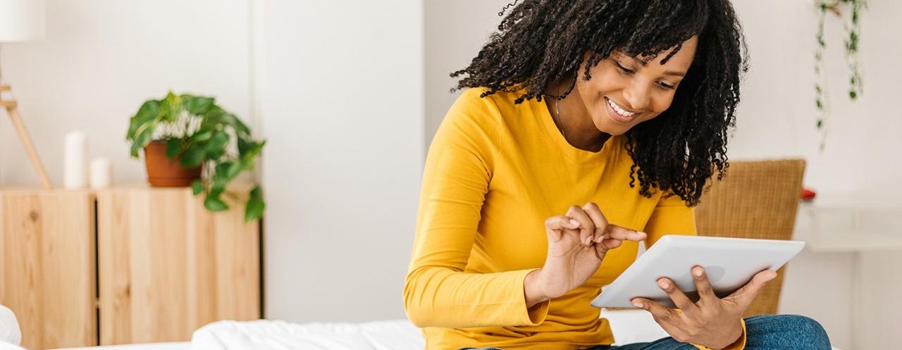 Young female looking at a tablet on a bed