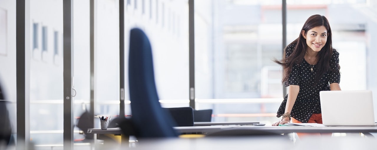 Woman standing at laptop in office