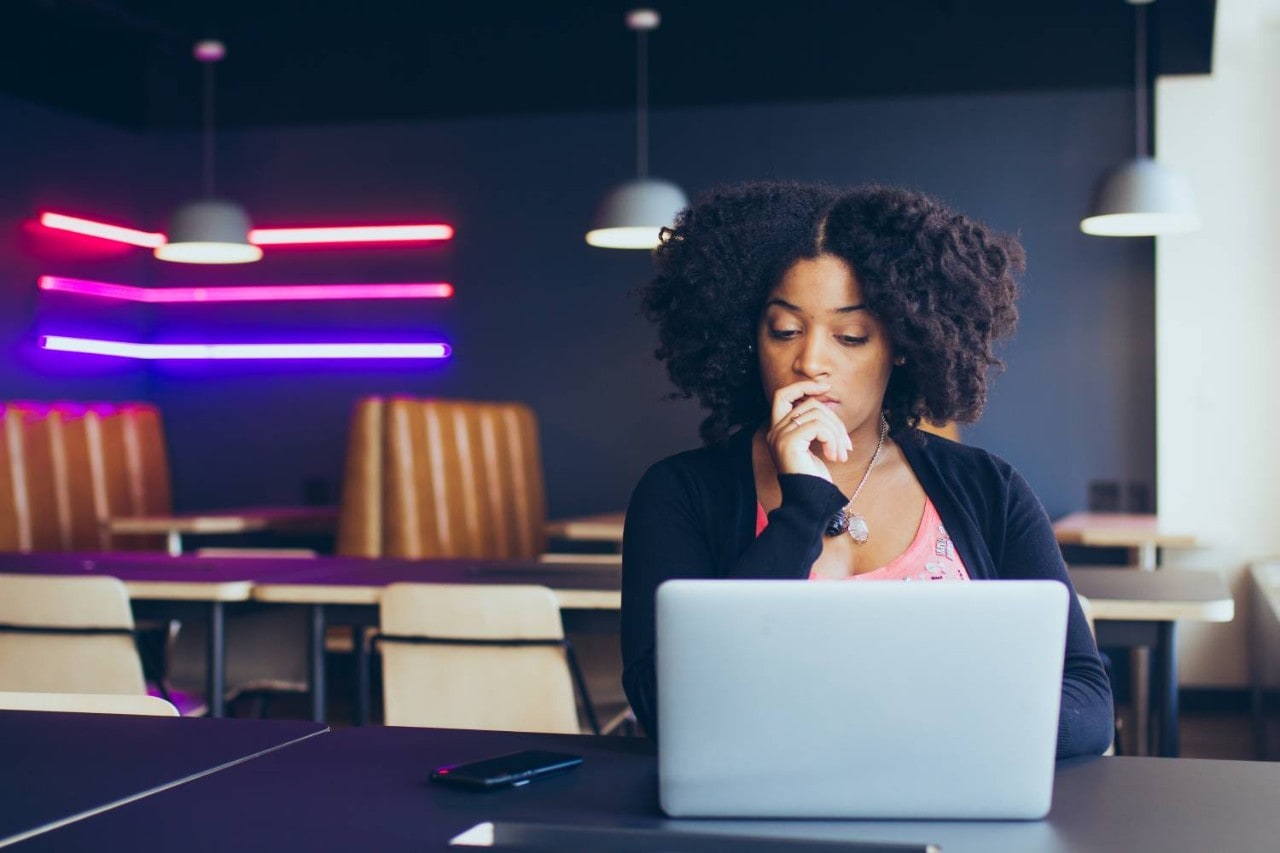  Woman sitting with a concentrated look at an open laptop computer