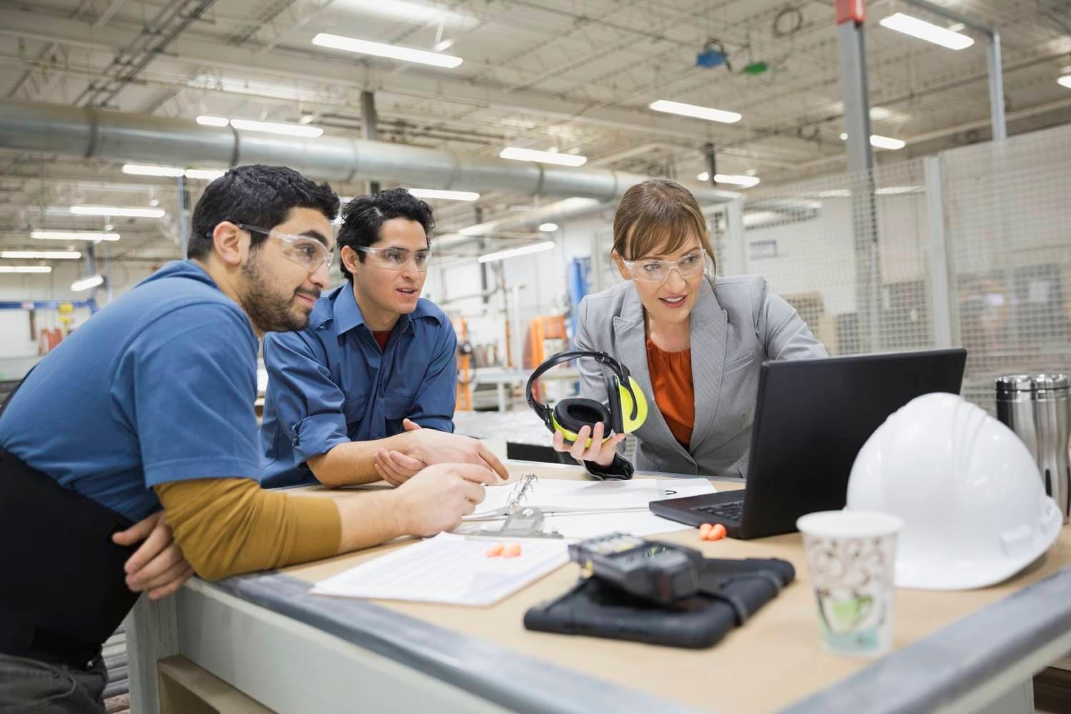 Woman and two men looking at laptop