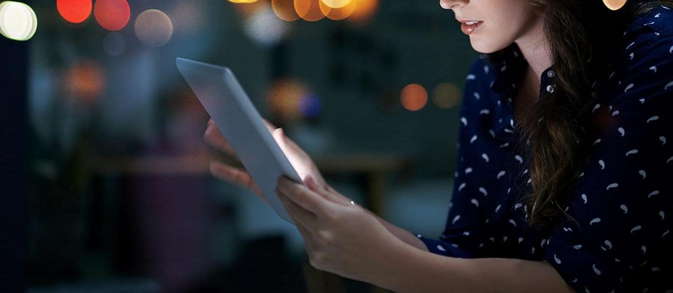 Young businesswoman working late on a digital tablet in an office